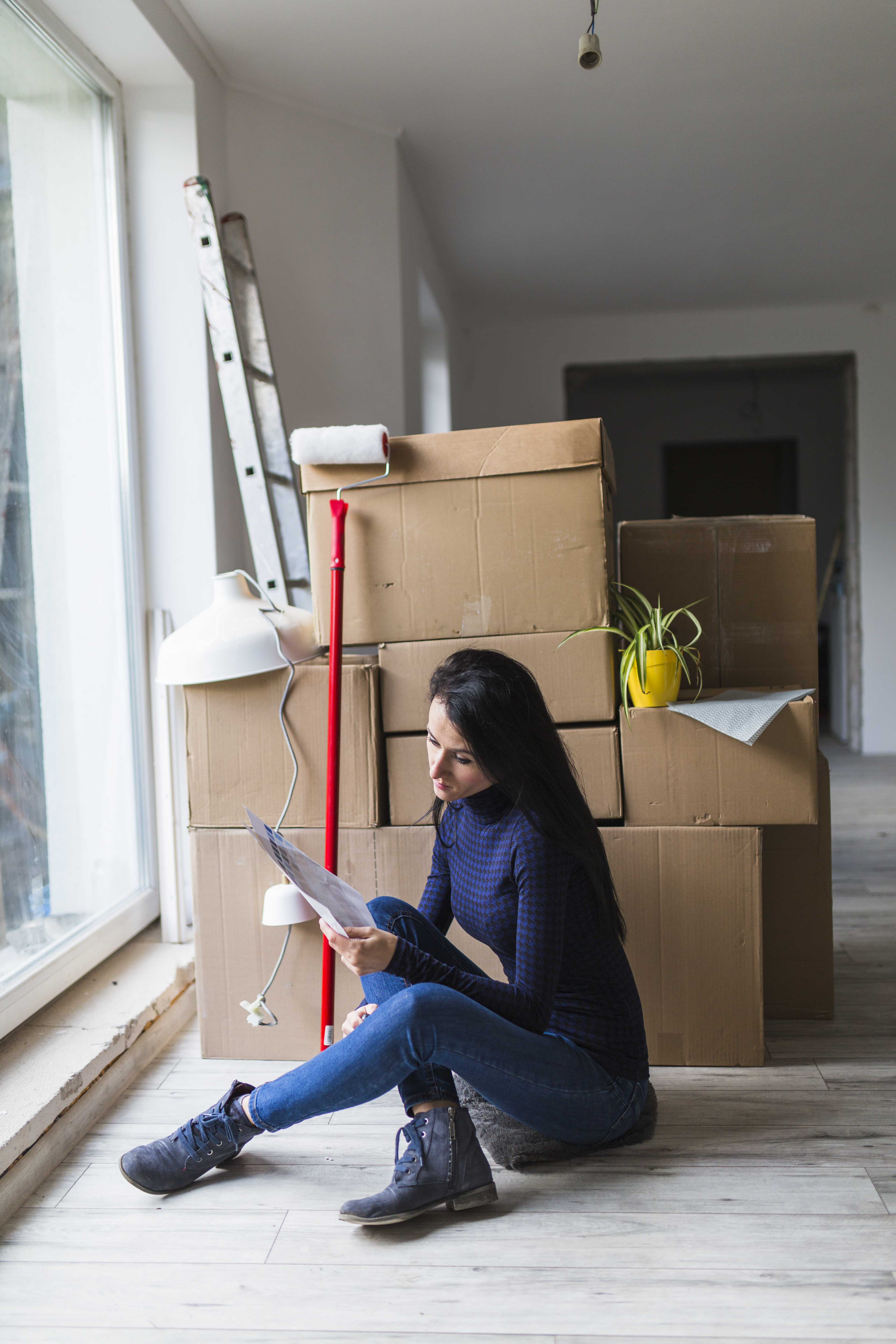 Woman near boxes paint roller